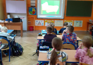 Dzieci oglądają filmik na tablicy interaktywnej