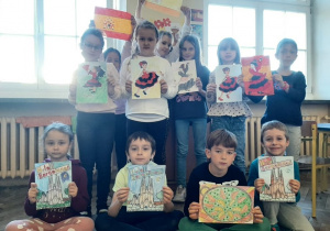 Klasa szkolna, uczniowie prezentują rysunki przedstawiające symbole Hiszpanii