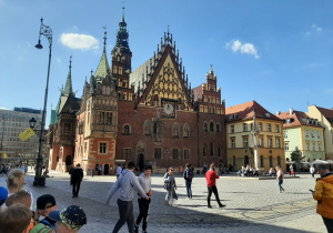 Wrocławski rynek, grupa uczniów oczekuje na wyprawę w poszukiwaniu krasnali.