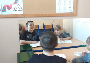 Zdjęcia przedstawiają dzieci w sali terapeutycznej podczas zajęć logopedycznych.