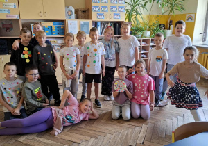 Sala lekcyjna, uśmiechnięci uczniowie prezentują swoje kreacje w kropki.