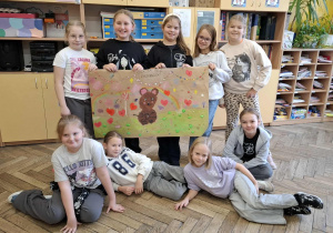 Sala lekcyjna, uśmiechnięci uczniowie prezentują wykonane podczas zajęć „Klasowe Drzewo Życzliwości”