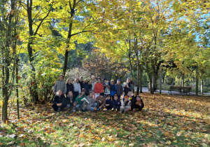 Jesienny park, uśmiechnięte i zadowolone dzieci na tle jesiennej przyrody.